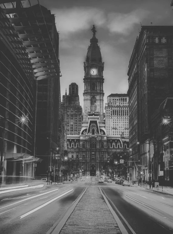 Dusk over Broad Street as headlight trails run toward the clock tower of Philadelphia City Hall