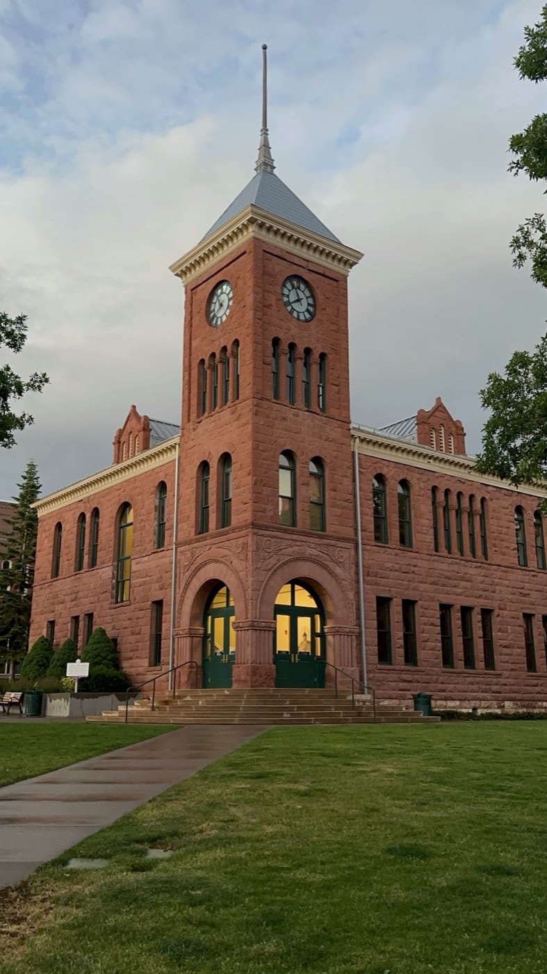 The 1894 Coconino County Courthouse glows at dusk, its sandstone clock tower presiding over downtown Flagstaff.