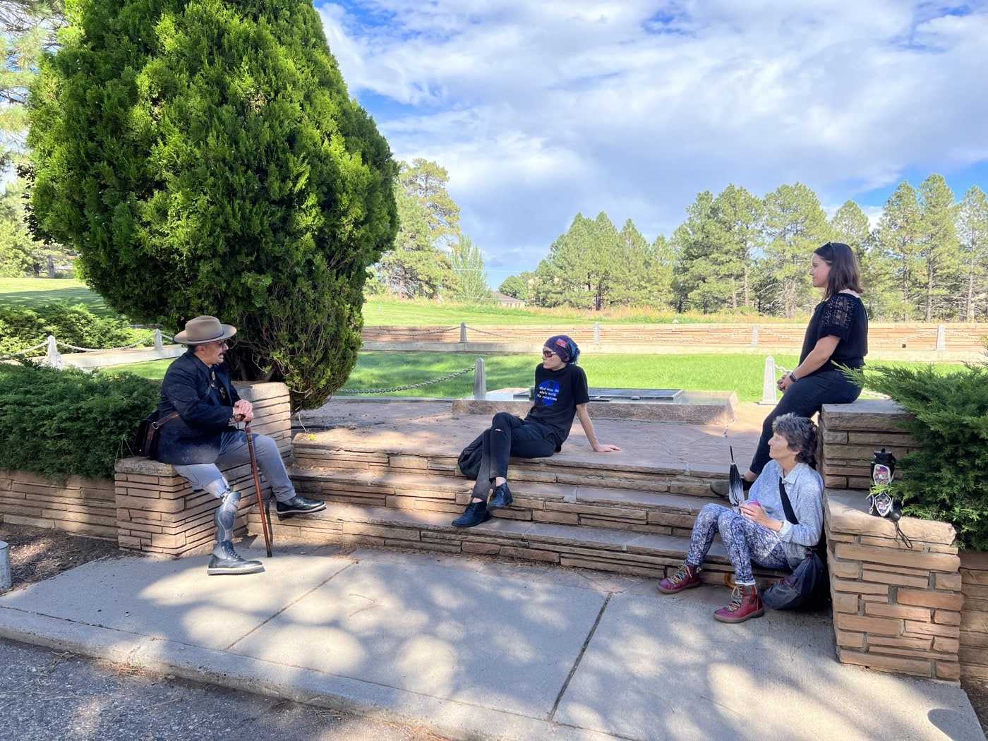 A guide sharing stories with guests seated on stone steps at Citizens Cemetery