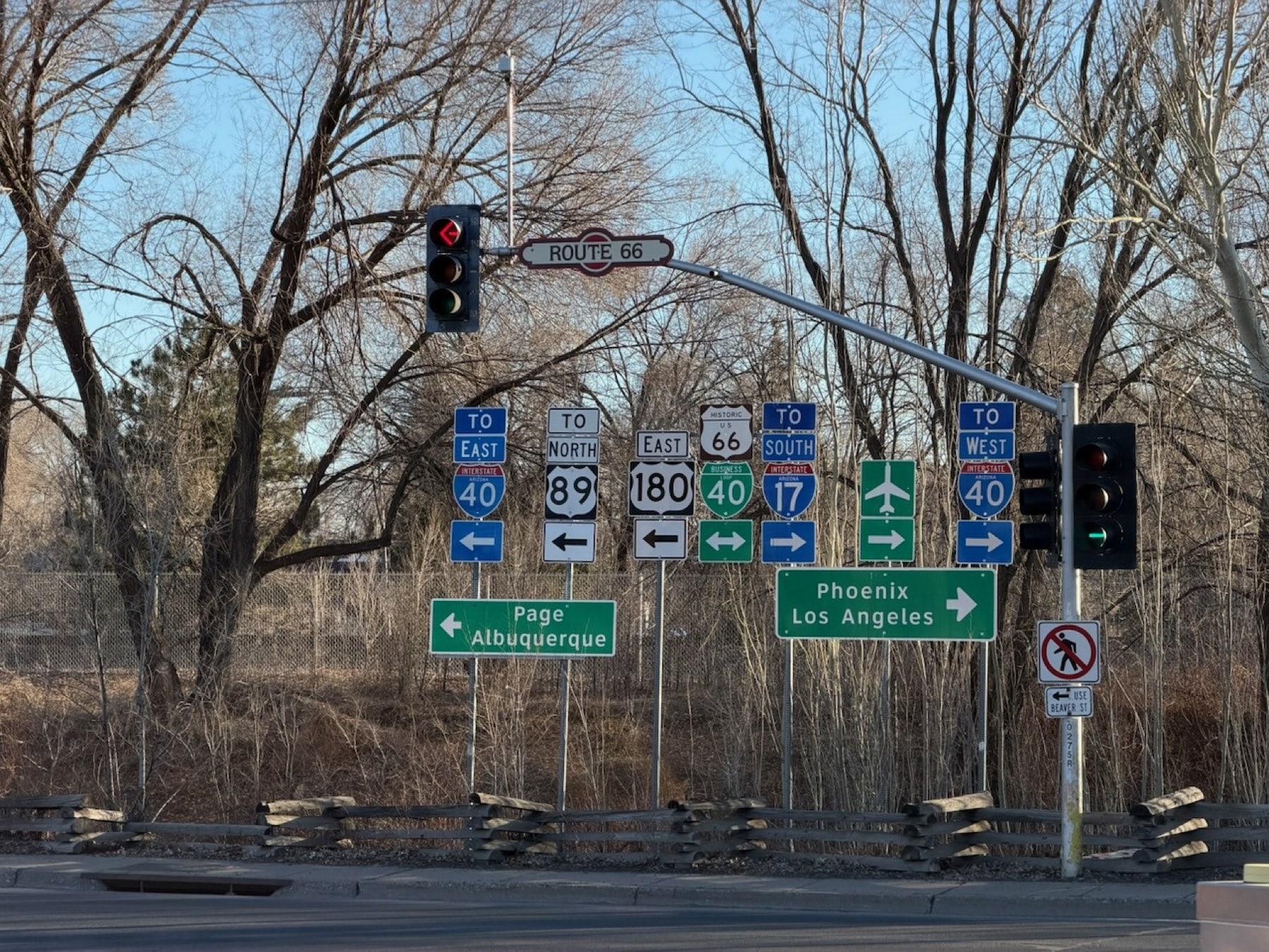 A forest of highway shields - Historic US 66, I-40, US 180 - marks the crossroads where the Mother Road still points travelers toward Phoenix and Los Angeles.
