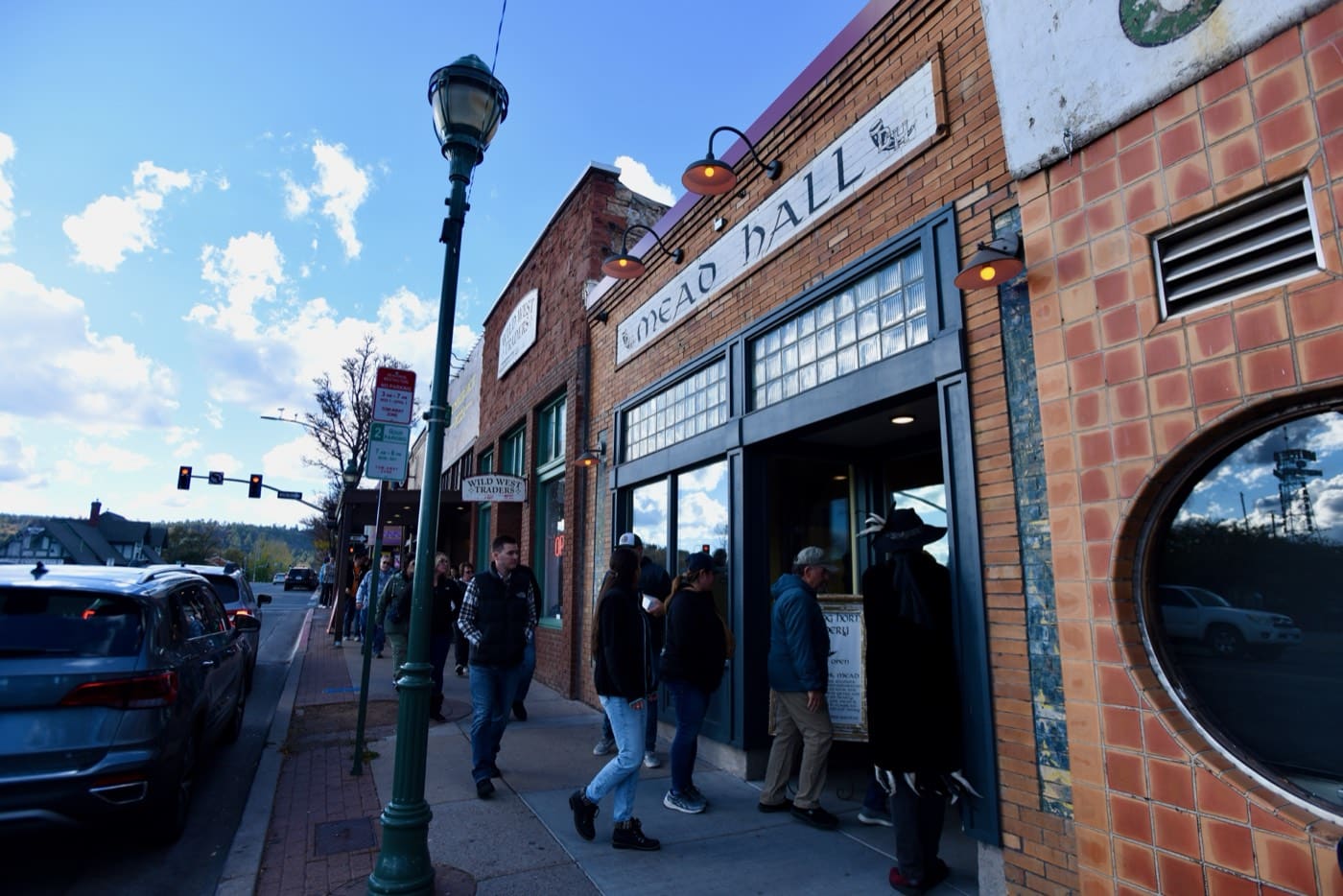 Guests file into the Mead Hall's brick and tile storefront as a costumed Freaky Foot Tours guide waits by the door on the Spirits With The Spirits haunted pub crawl through Flagstaff.