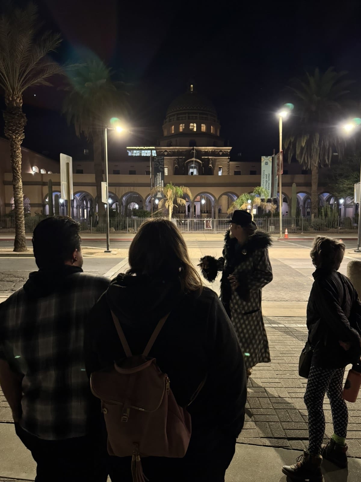A tour group beneath the tiled dome of the old Pima County Courthouse at night