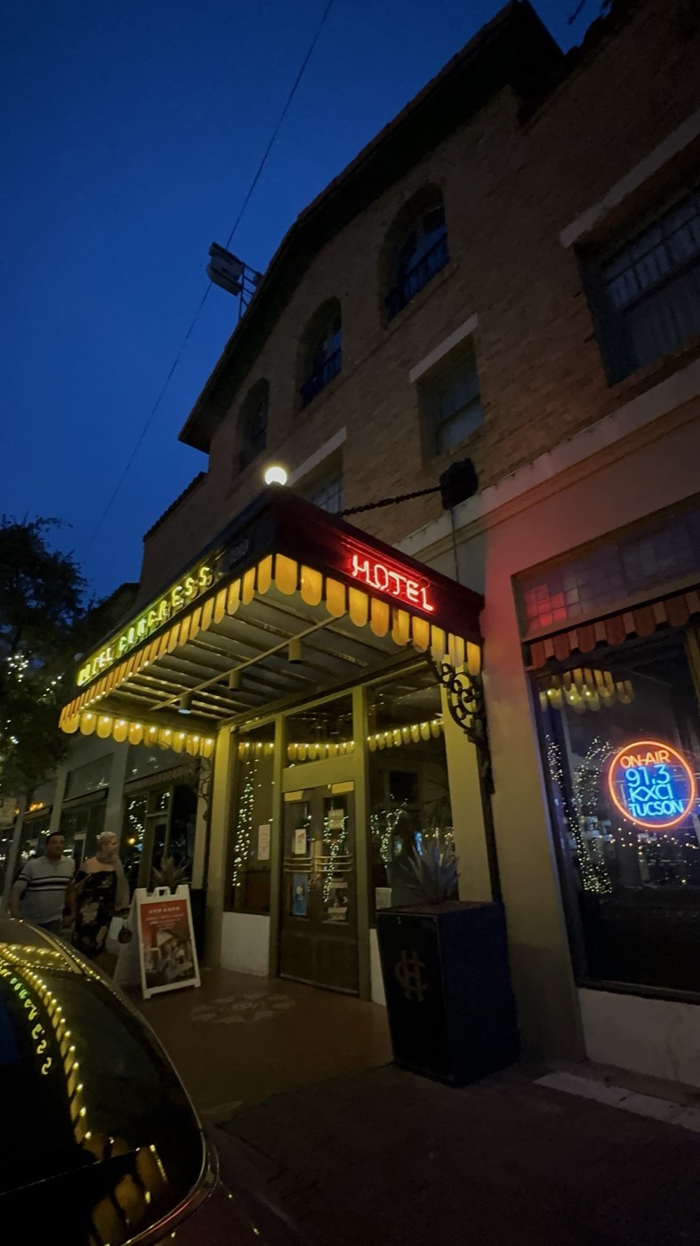 The lit canopy and neon of Hotel Congress at dusk on Congress Street