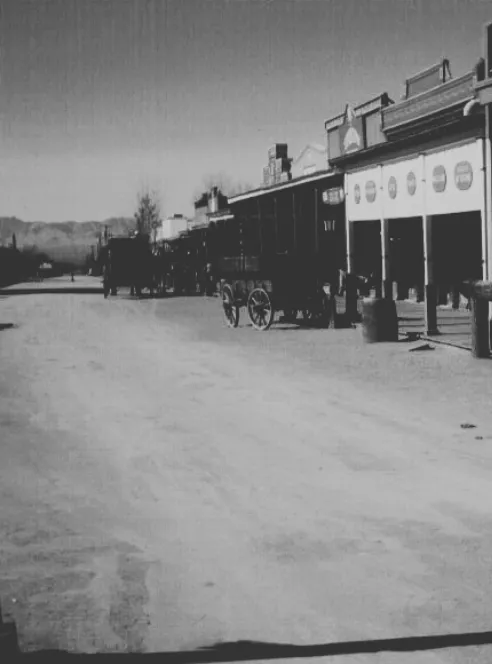 An early photograph of a dirt Allen Street in Tombstone with a wagon at the boardwalk
