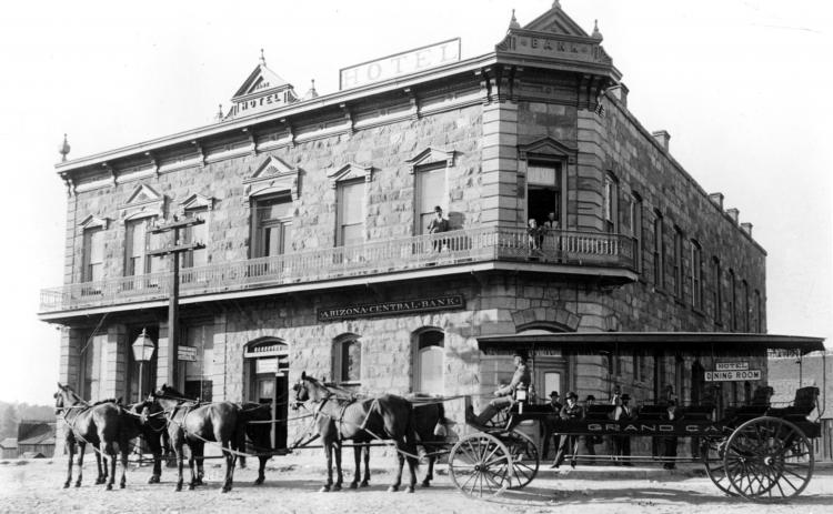 Historic stone hotel and bank with a horse-drawn stagecoach out front