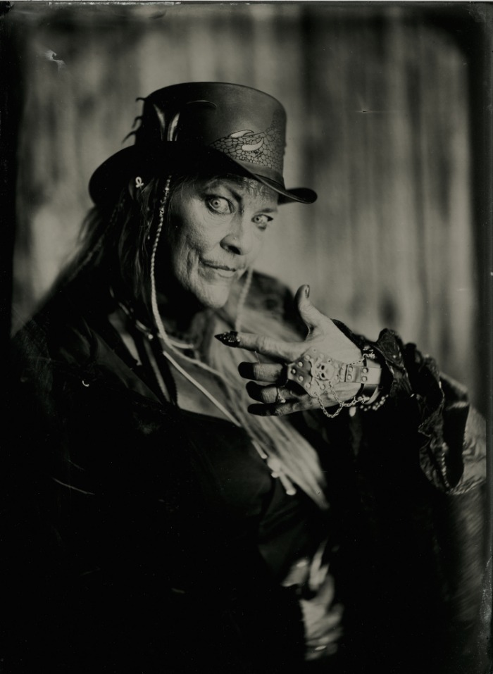 Tintype portrait of a woman in a leather top hat with braided hair