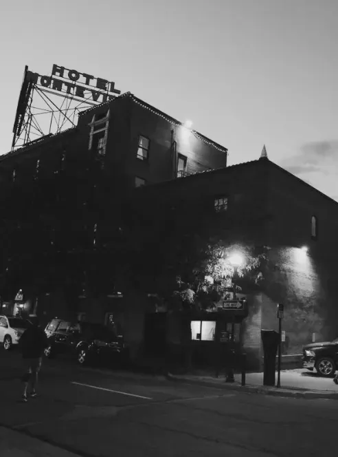The Hotel Monte Vista brick building lit at dusk in black and white