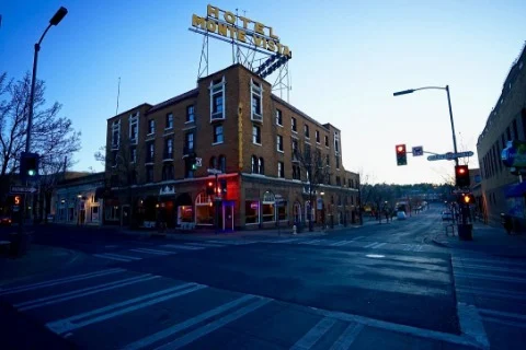 Hotel Monte Vista with its rooftop neon sign at a downtown Flagstaff corner at dusk