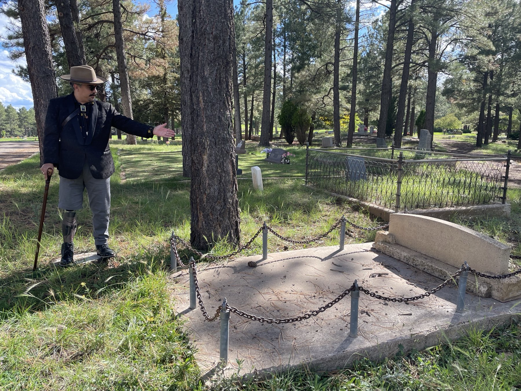 A Freaky Foot Tours guide gesturing toward a chained-off grave plot at Citizens Cemetery
